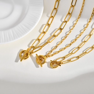 Three gold stainless steel OT buckle necklaces with different chain links on white marble