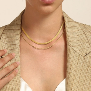Double-layered gold stainless steel necklace featuring flat snake chain on model