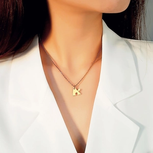 Model wearing a gold heart puzzle pendant necklace in polished stainless steel finish