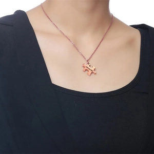 Detail of rose gold puzzle piece necklace with connected engraving on a model