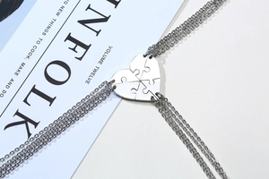 Detail of four-piece stainless steel heart puzzle pendant necklaces for friendship
