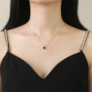 Golden stainless steel necklace with square emerald zircon worn on neck by a model