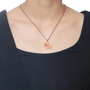 Detail of rose gold puzzle piece pendant with we will engraving on a woman neck