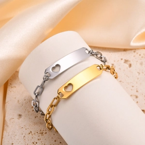 Detail of gold and silver kids curved plate bracelets with heart cutout on silk