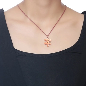 Detail of rose gold puzzle piece necklace engraved with always be on black fabric