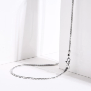 Dettaglio di una sottile collana a catena serpente argento con chiusura a moschettone