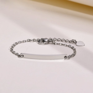 Macro detail of silver stainless steel ID bracelet with blank plate and heart charm