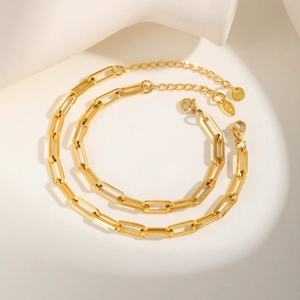 Close-up of gold paperclip chain jewelry showing the K18 hallmark and lobster clasp
