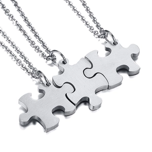 Detailed view of three-piece puzzle pendant necklaces in brushed matte stainless steel finish