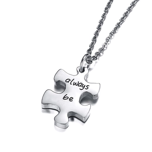 Close-up of puzzle piece pendant in silver stainless steel with always be engraving