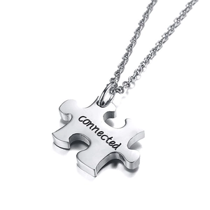 Close-up of silver puzzle pendant necklace with connected engraving on a fine chain