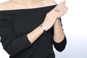 Detail eines Silikon-Notfallarmbands mit rotem Lebensstern auf einer Stahlplatte