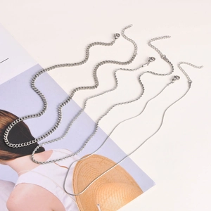 Détail de colliers en acier inoxydable argenté, mailles gourmette, torsadée et serpent