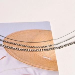 Détail d'un ensemble de chaînes argentées : torsadée, serpent et maille gourmette