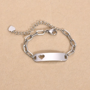 Close-up of stainless steel kids ID bracelet with hollow heart cutout and lobster clasp