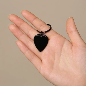 Macro detail of a sleek black heart-shaped metal keychain tag with smooth finish