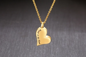 Makroaufnahme von Herz-Ascheanhänger aus Gold mit Forever In My Heart Gravur
