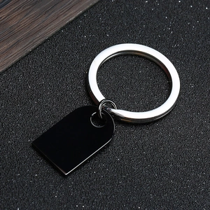 Close-up of a minimalist heart-shaped black stainless steel tag with silver keyring