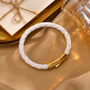 Gros plan détaillé d'un bracelet en cuir tressé blanc avec un fermoir magnétique doré
