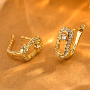 Macro view of gold oval earrings with micro-pave cubic zirconia and U-shaped clasp