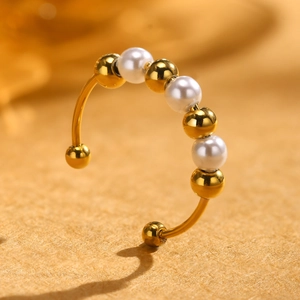 Detail of gold-plated stainless steel ring with alternating white faux pearls and beads