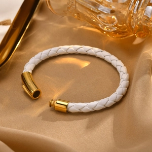 Vue détaillée d'un bracelet en cuir tressé blanc avec fermoir magnétique doré