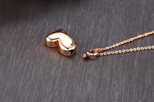 Makroaufnahme von herzförmigem Urnenanhänger in Roségold mit eingraviertem Spruch
