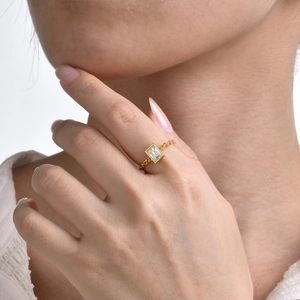 Fashionable 18K gold chain ring featuring a rectangular zircon on a female model hand