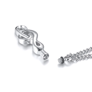 Macro shot of musical treble clef urn necklace with screw opening at bottom