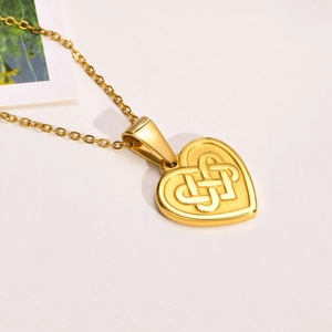 Nahaufnahme der goldenen Herz-Halskette mit filigraner keltischer Knotengravur