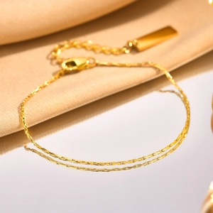 Close-up of gold-plated stainless steel chain bracelet with a rectangle tag and lobster clasp