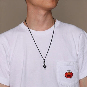 Detailed macro view of a men's black stainless steel treble clef musical note pendant necklace