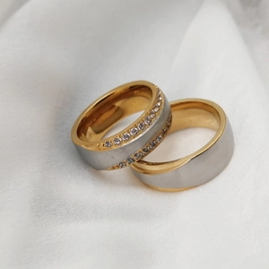 Minimalist stainless steel couple rings with cubic zirconia inlay on white silk fabric