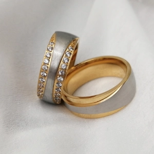Macro detail of stainless steel couple rings with cubic zirconia and brushed metal finish