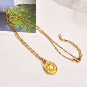 Detailansicht der goldenen Halskette mit ovalem Sonnen-Mond-Anhänger und verstellbarer Kette