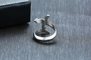 Macro detail of silver dagger ring showing brushed steel texture and curved sword design
