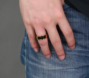 Close-up of a gold stainless steel ring with a black onyx inlay worn on a male hand