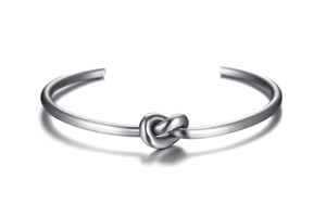 Detailed close-up of a silver knot cuff bracelet in minimalist stainless steel finish