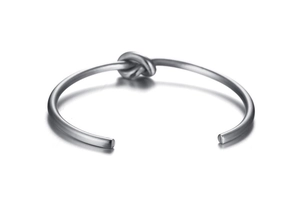 Detail of matte brushed titanium steel knot cuff bracelet with open adjustable design