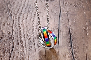 Close-up of interlocking rainbow double ring pendant on polished steel chain
