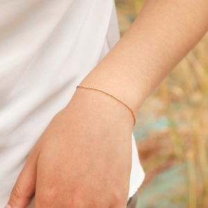 Elegant gold square hammer link bracelet for women shown worn on a wrist in nature