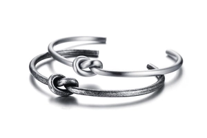 Detail of 3.4mm titanium steel knot bangles in polished silver and vintage grey finish