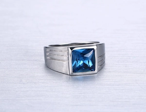 Macro shot of silver stainless steel men's ring featuring a square blue crystal inlay