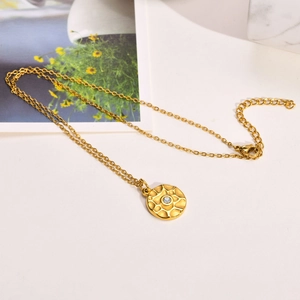 Detail der goldener Kette mit gehämmerter Sonnenanhänger, weißem Zirkon und Karabiner
