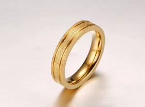 Détail de la bague dorée avec finition sablée mate et doubles rainures gravées