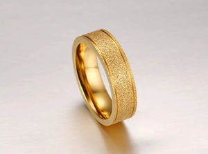 Gros plan d'une bague dorée sablée avec centre évidé et bords polis miroir