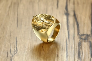 Detailed close-up of golden Egyptian Pharaoh Tutankhamun relief on stainless steel ring