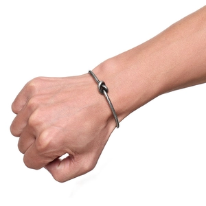 Macro detail of the titanium steel knotted bangle showing its vintage matte finish