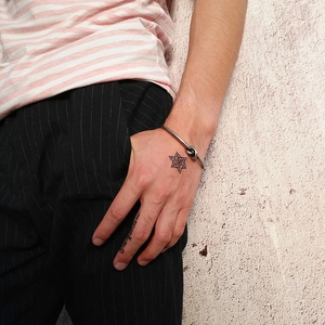 Silver knot cuff bracelet in titanium steel styled on wrist with casual street fashion