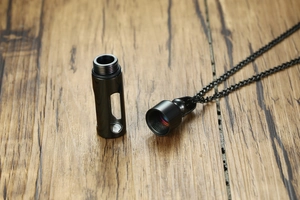 Détail du pendentif flacon de parfum noir avec bouchon fileté et fenêtre en verre